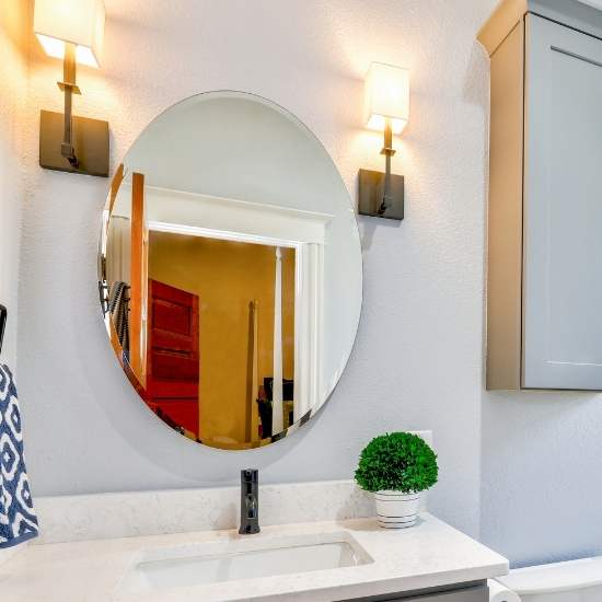 This pictures shows the elegance of a large, square mirror placed above the kitchen sink in a home. With a beautiful frame around it, this mirror is a great way to add style in your home.