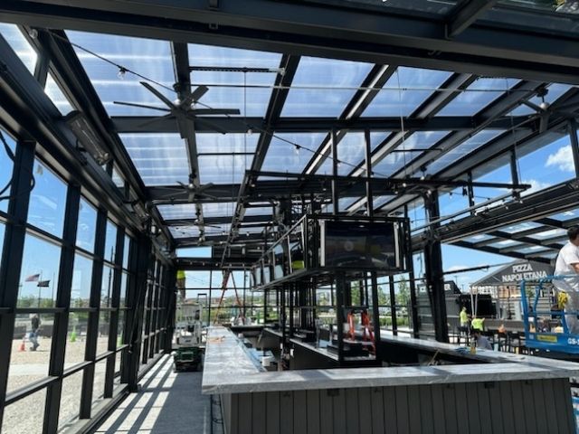 Polycarbonate-Roofing-img This picture is taken from inside a home and is looking through patio doors onto the patio. It features beautiful, white french doors. Pane Free Glass in Manchester, NH, can turn this dream into a reality for you in your home.